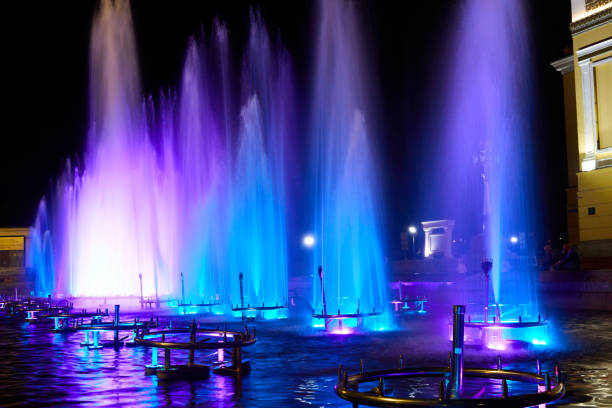 jets of the city fountain illuminated by blue light at night