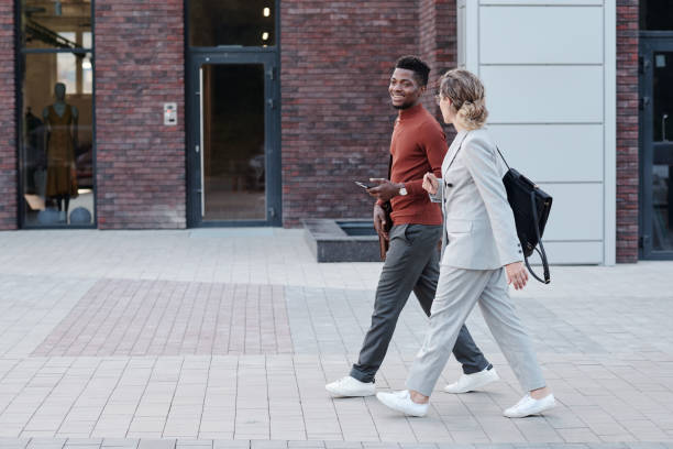 istock Two young colleagues interacting while moving along modern boutique 1327810732