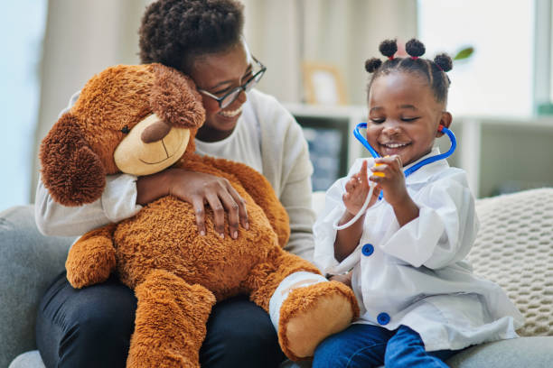 colpo di un'adorabile bambina e di sua madre che giocano con uno stetoscopio nella sala d'attesa di uno studio medico - teddy bear baby toy stuffed animal foto e immagini stock