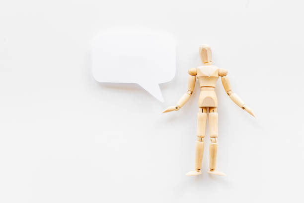 istock Wooden man figure presenting and showing on speech bubble banner 1327812242
