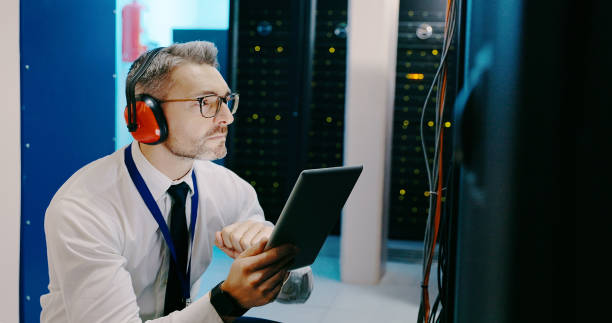 istock Shot of a male technician using a digital tablet while working in a server room 1327816095
