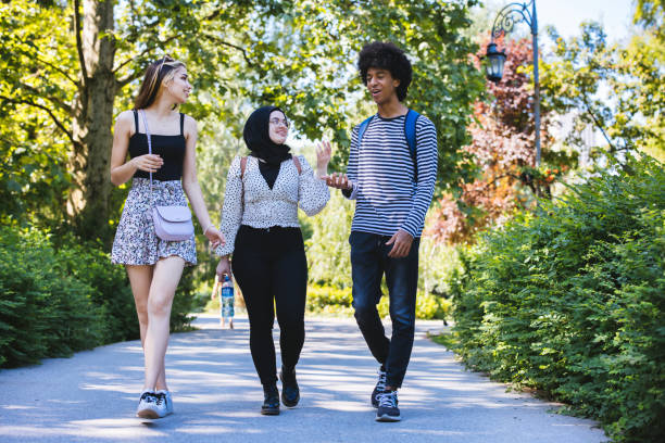 istock Friends walking together in a park 1327816415