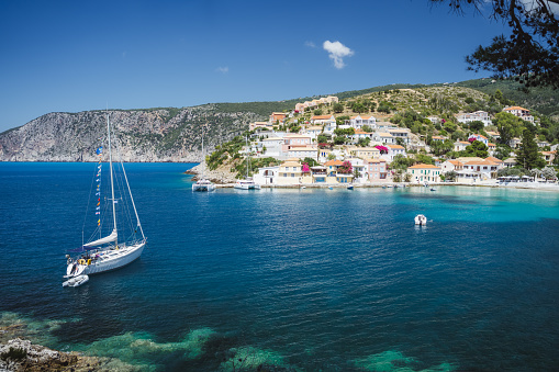 Sailing yacht boat in small bay of Assos cute town on Ionian coast, Kefalonia island, Greece.