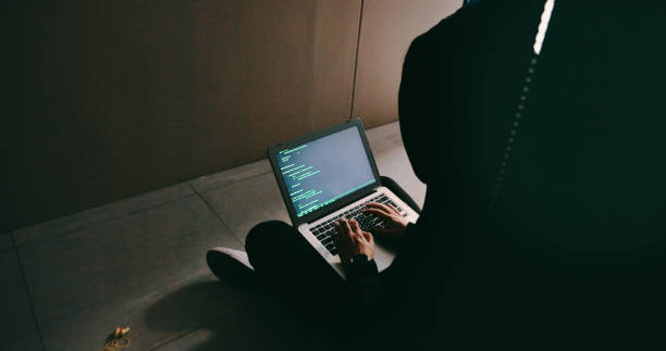 foto de un joven hacker usando una computadora portátil en una sala de servidores - employee theft fotografías e imágenes de stock