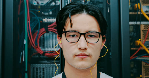 istock Shot of a young man using earphones while working in a server room 1327817736