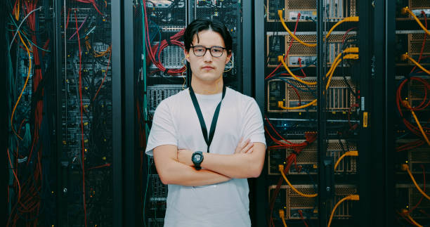 Shot of a young man using earphones while working in a server room