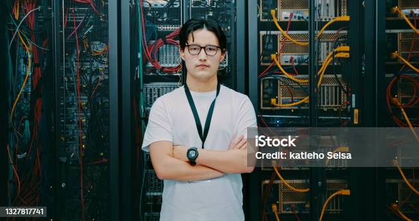 Shot Of A Young Man Using Earphones While Working In A Server Room Stock Photo - Download Image Now