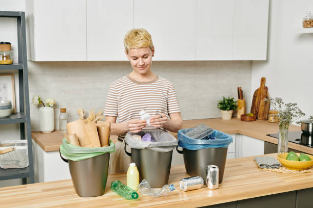 istock Pretty female sorting various kinds of trash 1327817865