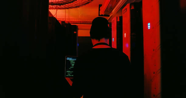 istock Shot of a hacker carrying a laptop in a server room 1327818230