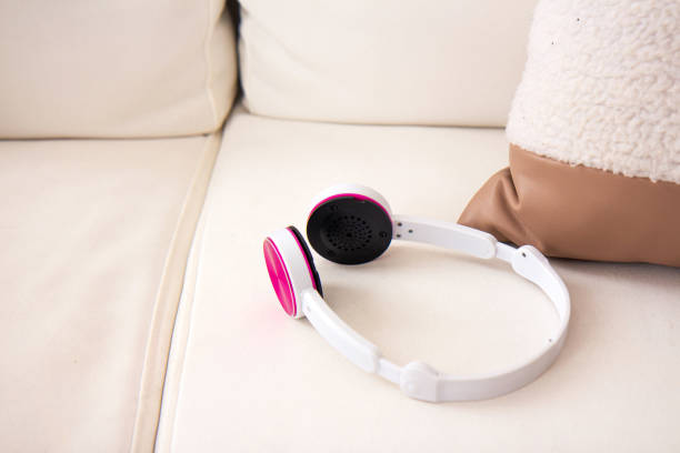 istock White headphones on a light sofa with pillows 1327820466