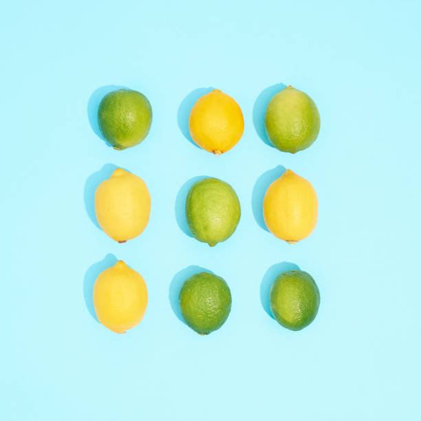Fresh limes and lemons on blue background.