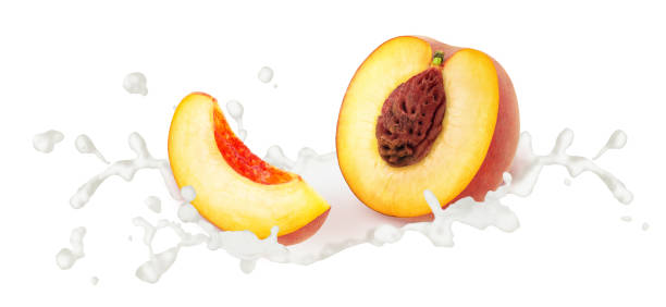 istock Cutted peach in milk splashes isolated on white background. 1327822996