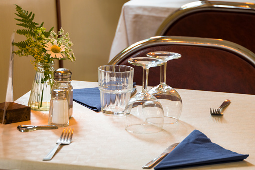Close up chic table setting in a restaurant with antique silverware and crockery