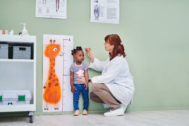 Shot of a doctor measuring an adorable little girl’s height during a consultation Caring for your kid from small to tall paediatrician stock pictures, royalty-free photos & images