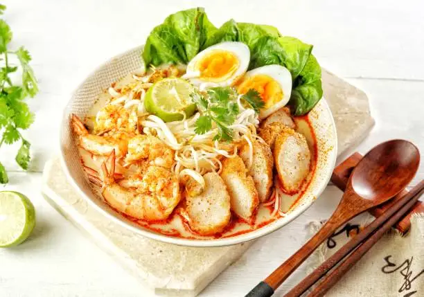 Singapore Laksa, a popular local dish served in spicy curry gravy with coconut milk, bean sprout, fish ball or fish cake, shrimp and egg boiled over noodles or vermicelli underneath.