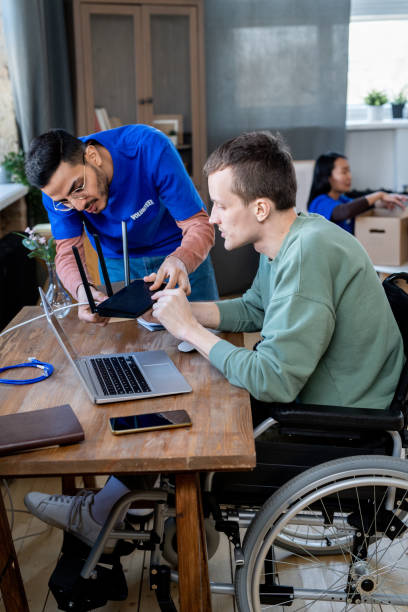 istock Male volunteer helping disabled man with router 1327831490
