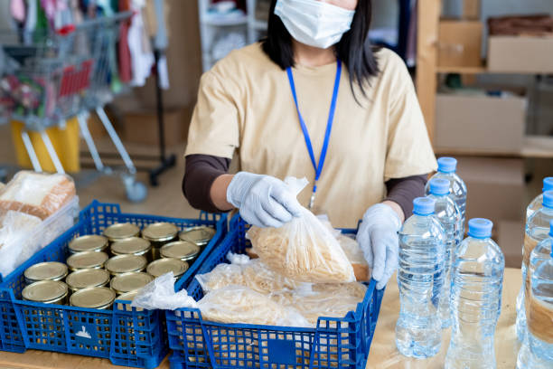 istock Female volunteer putting free food into plastic boxes 1327831686