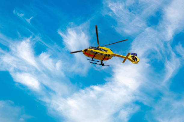 Paramedic rescue helicopter against blue cloud sky. Starting helicopter, flying ambulances, air ambulance in Germany. Emergency doctor. stock photo