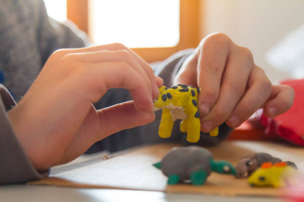 istock Child moulds from plasticine on table. 1327837734