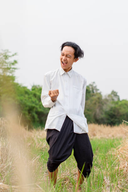 istock Young men standing wearing a white shirt at the field 1327841256