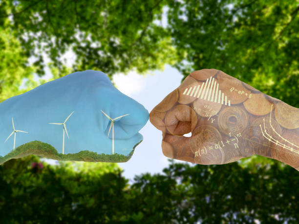 Sustainable fist bump Cooperation between economy and renewable energy represented by coins and wind power. climate justice photos stock pictures, royalty-free photos & images