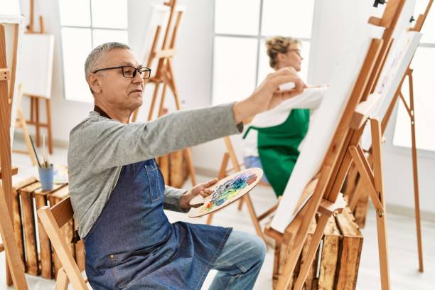istock Two middle age artist concentrated painting at art studio. 1327844086