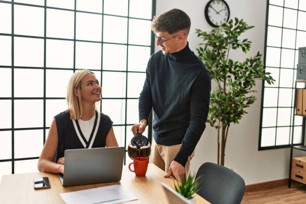 istock Two business workers smiling happy working and drinking coffee at the office. 1327845188