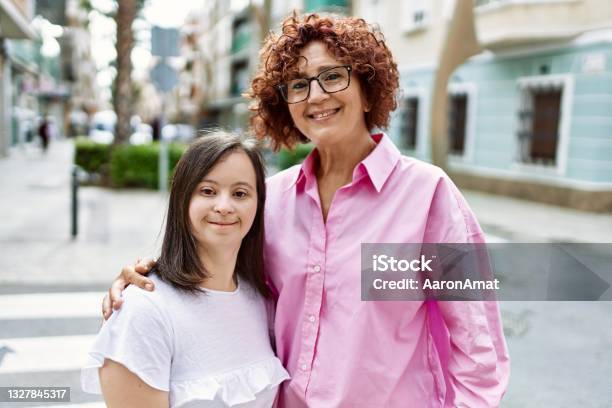 Mature Mother And Down Syndorme Daughter Smiling Happy And Friendly Outdoors Stock Photo - Download Image Now