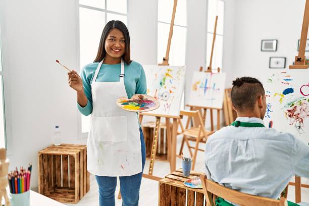 istock Young latin painter couple smiling happy painting at art studio 1327845742