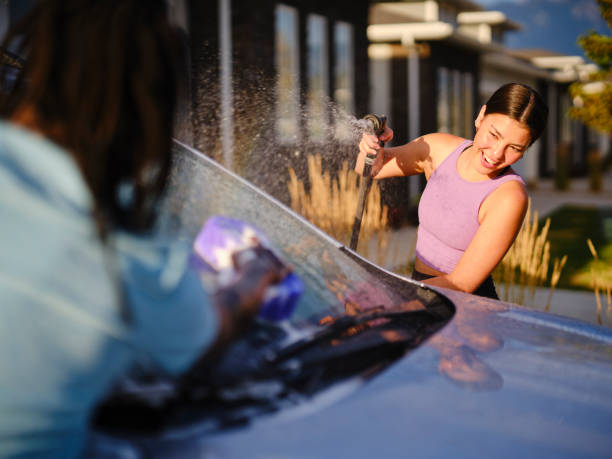 istock Young Couple Washing a Car in a Driveway 1327846193