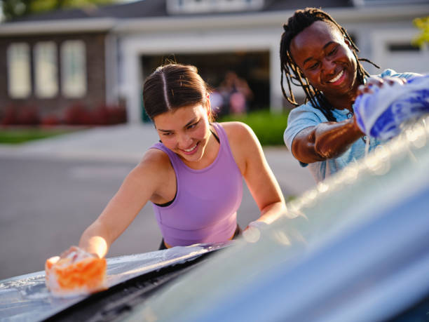 istock Young Couple Washing a Car in a Driveway 1327846200