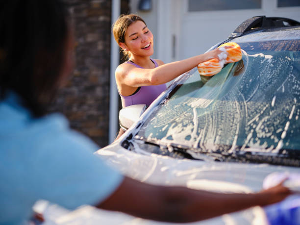 istock Young Couple Washing a Car in a Driveway 1327846209