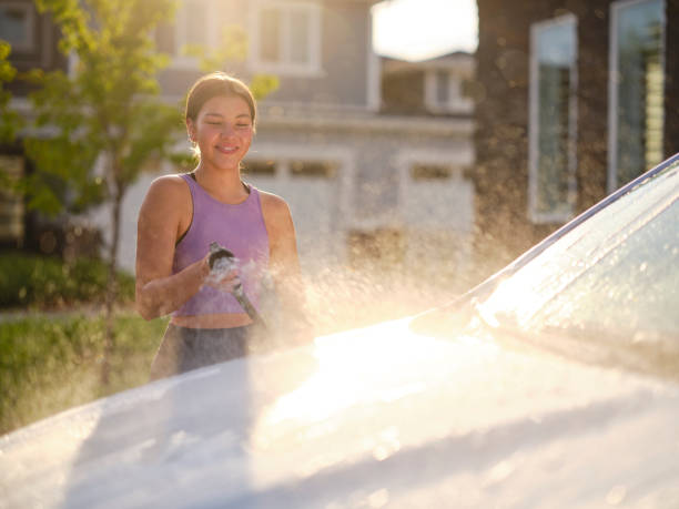 istock Young Couple Washing a Car in a Driveway 1327846363