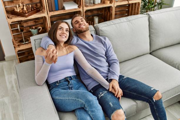 istock Young caucasian couple relaxed sitting on the sofa hugging at home. 1327846971