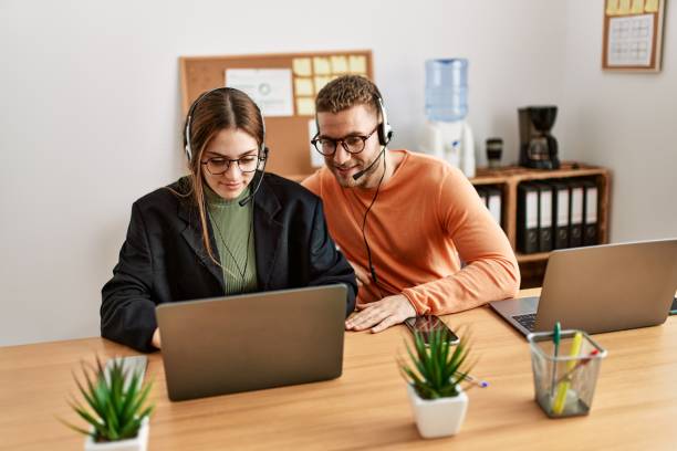 istock Two caucasian call center agents working at the office. 1327847029