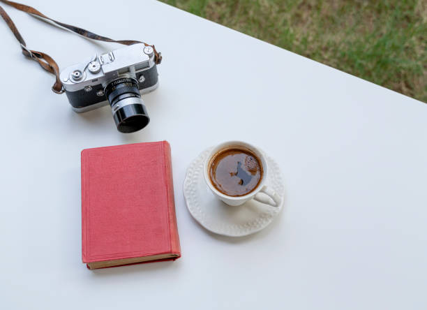 istock Vintage camera and book with a cup of coffee 1327847122