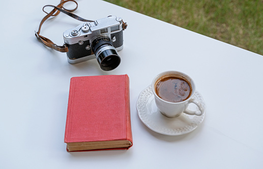 Vintage camera and book with a cup of coffee