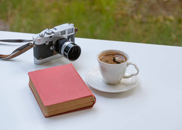 istock Vintage camera and book with a cup of coffee 1327847280