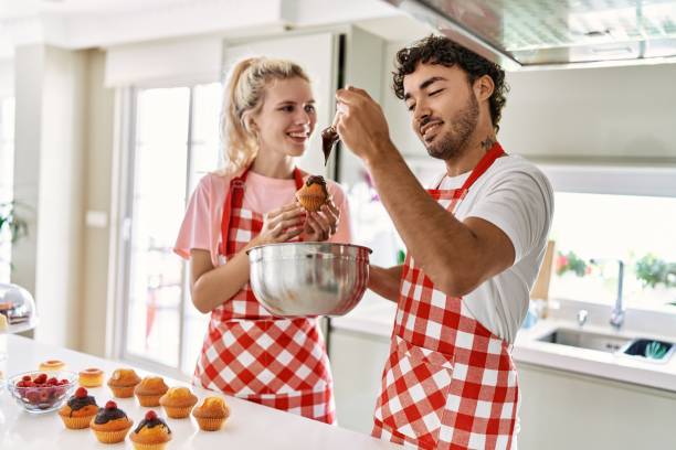 istock Young couple smiling happy cooking sweets at kitchen. 1327848010