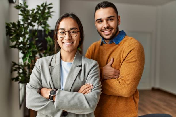 two business workers smiling happy standing with arms crossed gesture at the office. - businessman business arms crossed business person imagens e fotografias de stock