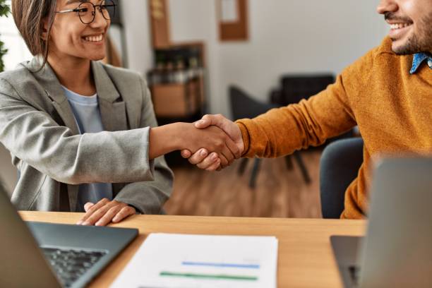 istock Two business workers shaking hands at the office. 1327850491