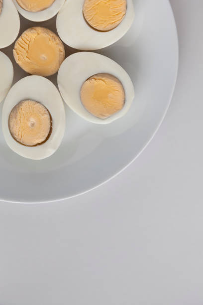 istock Boiled egg halves on a white plate on a light background. 1327858892
