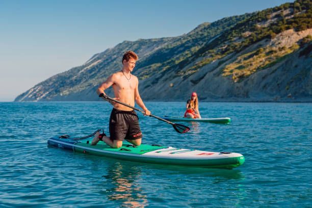 28. mai 2021. anapa, russland. paar auf stand up paddle board am blauen meer. menschen urlaub auf red paddle sup board in ruhiger see. - editorial women paddleboard surfboard stock-fotos und bilder