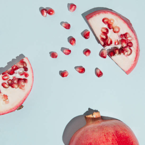 istock Creative pomegranate layout made of seeds and pomegranate cut open on the pastel blue background. Fresh fruit minimalism concept. 1327862997