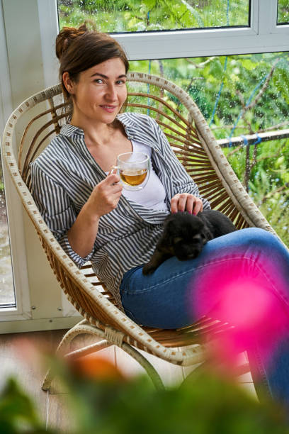 istock Smiling woman holding cup and drinking tea 1327864392