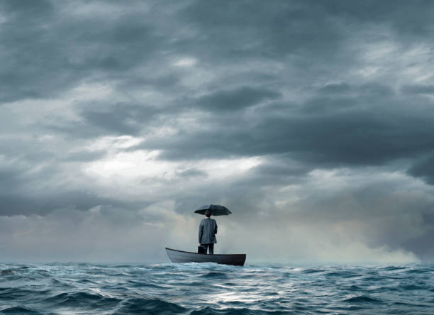 homme avec un parapluie échoué sur un bateau - stranded photos et images de collection