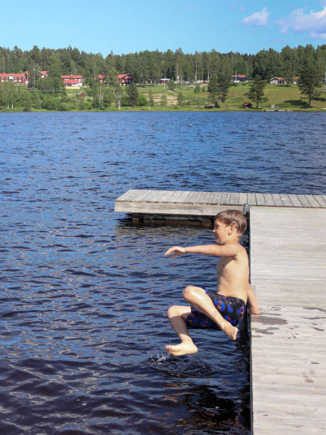 istock Boy is jumping into the water from jetty 1327867394