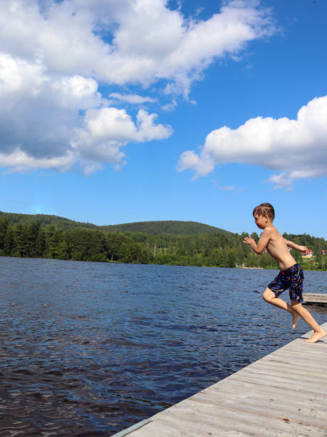 istock Boy is jumping into the water from jetty 1327867459
