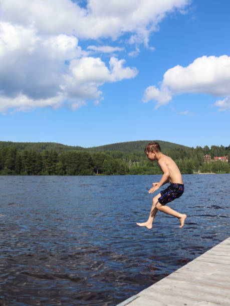 istock Boy is jumping into the water from jetty 1327867481