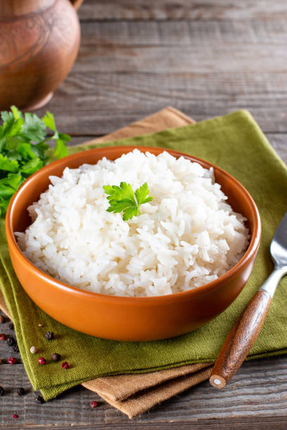 istock Cooked rice in a bowl on an wooden table 1327868847